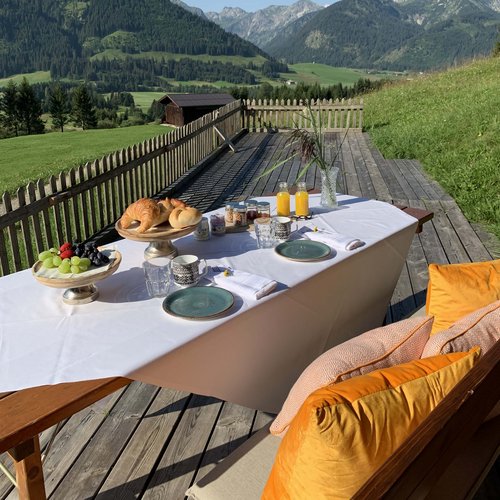 Hotel Sonnenhof Frühstückstisch mit Croissants und Saft auf Terrasse in den Bergen