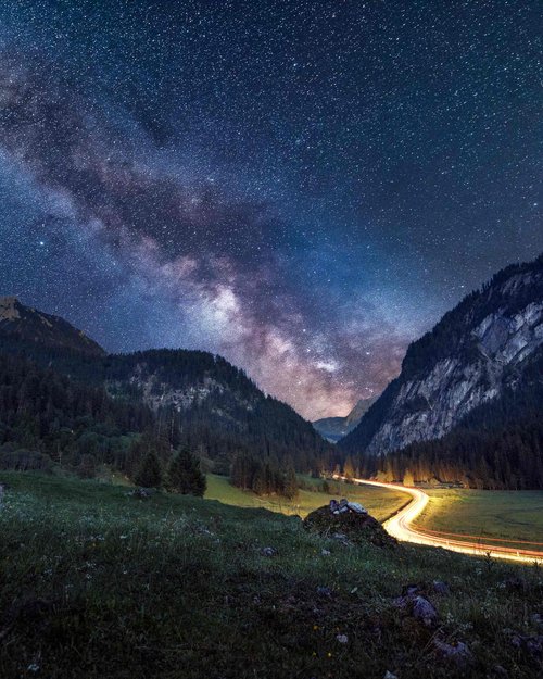 Hotel Sonnenhof Sternenhimmel und Milchstraße über einem Tal mit einer leuchtenden Straßenkurve