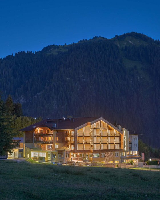 Hotel Sonnenhof Beleuchtetes Hotel vor Bergkulisse bei Nacht