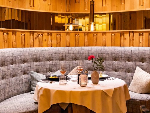 Hotel Sonnenhof Gemütliche runde Essecke mit Holzwänden und warmer Beleuchtung