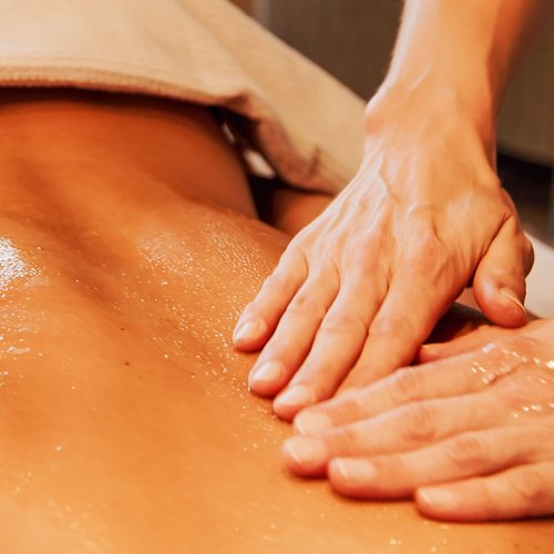 Hotel Sonnenhof Ölmassage auf dem Rücken einer Person in einem Spa
