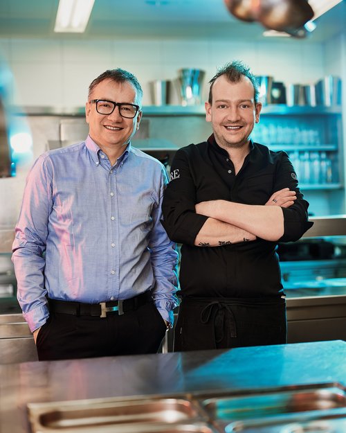 Hotel Sonnenhof Zwei Männer, ein Koch und ein Mann im Hemd, in einer Restaurantküche