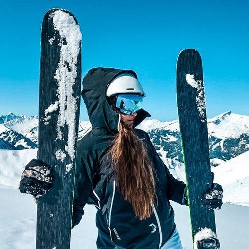 Hotel Sonnenhof Frau mit Ski und Helm auf schneebedecktem Berg bei sonnigem Wetter