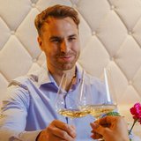 Hotel Sonnenhof Mann und Frau stoßen mit Weißweingläsern in Restaurant an