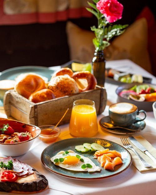 Hotel Sonnenhof Frühstückstisch mit Spiegelei, Lachs, Brötchen, Orangensaft und Kaffee