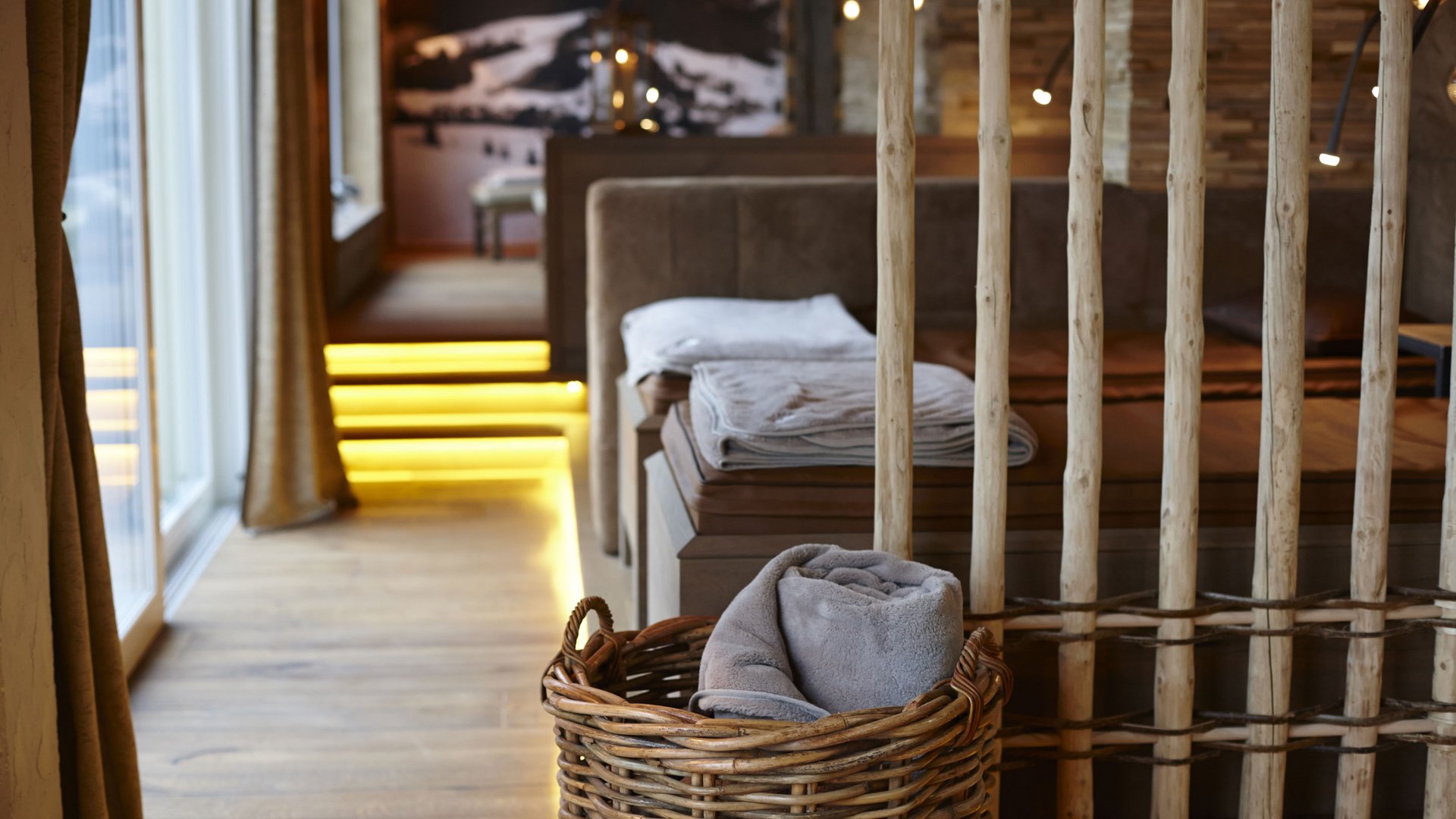 Hotel Sonnenhof Korb mit eingewickelter Decke in gemütlichem Innenraum mit Holz und indirekter Beleuchtung