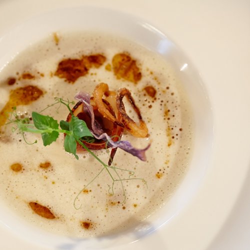 Hotel Sonnenhof Feine Suppe mit Schaum, gebratenen Tintenfischringen und Kräuter garnieren