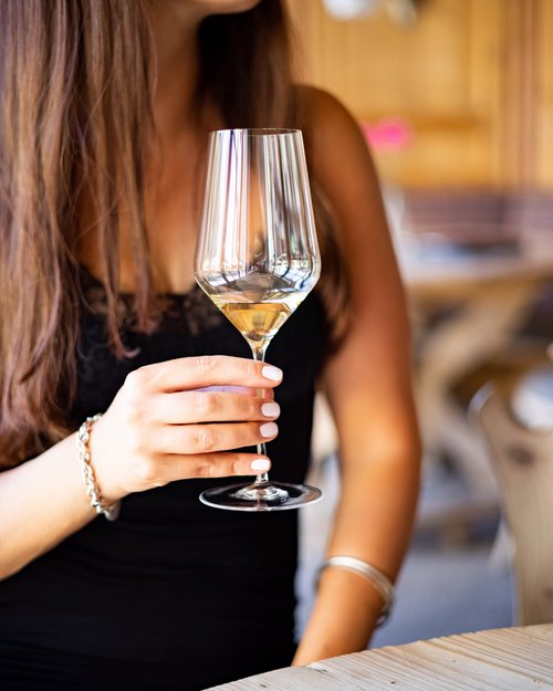 Hotel Sonnenhof Frau hält Weinglas mit weißem Wein in einem Restaurant