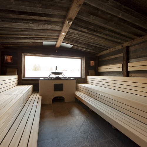 Hotel Sonnenhof Helle Holzsauna mit großen Sitzbänken und Fenster mit Außenaussicht
