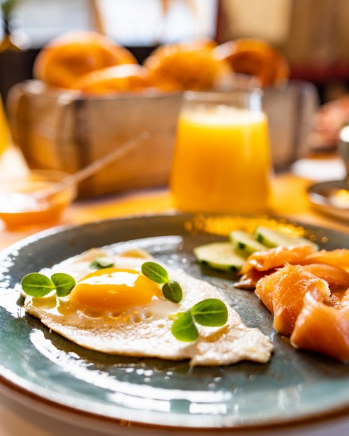 Hotel Sonnenhof Spiegelei mit Lachsscheiben, Gurken und Orangensaft beim Frühstück