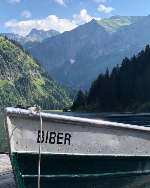 Hotel Sonnenhof Boot namens Biber am Steg mit Bergkulisse und See im Hintergrund