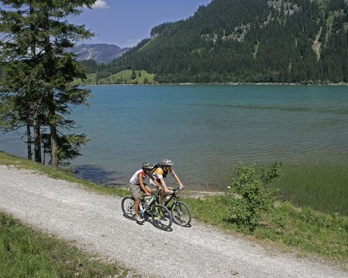 Hotel Sonnenhof Zwei Radfahrer auf einem Waldweg neben einem See in den Bergen