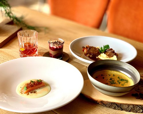 Hotel Sonnenhof Vorspeise, Suppe, Hauptspeise, Dessert und Drink auf rustikalem Holztisch angerichtet