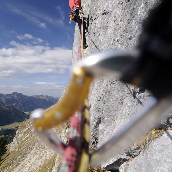 Hotel Sonnenhof Kletterer gesichert mit Seilen erklimmt steile Felswand
