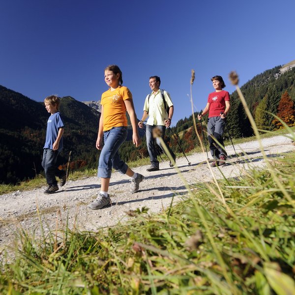 Hotel Sonnenhof Familie wandert auf Bergweg bei sonnigem Wetter im Herbst