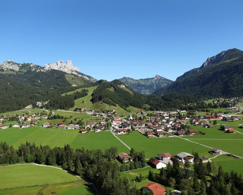Hotel Sonnenhof Panoramablick auf ein Dorf in einem grünen Tal mit Bergen im Hintergrund