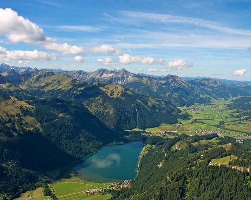 Hotel Sonnenhof Berglandschaft mit See, Wäldern und Ortschaften unter blauem Himmel
