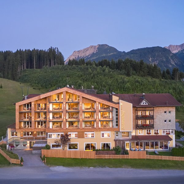 Hotel Sonnenhof Hotel mit beleuchteten Fenstern in den Bergen bei Abenddämmerung