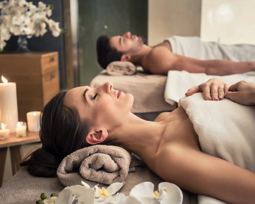 Hotel Sonnenhof Paar genießt entspannende Spa-Massage in ruhigem Raum mit Kerzen und Blumen