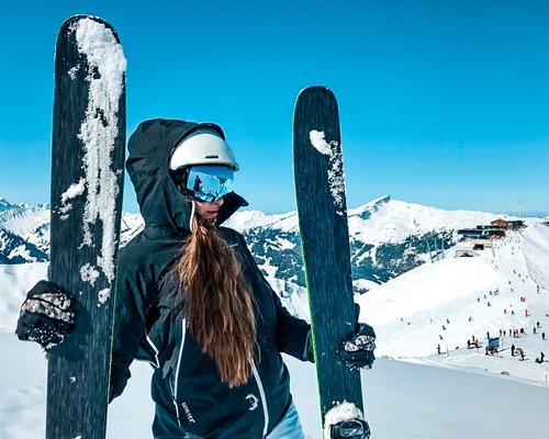 Hotel Sonnenhof Frau mit Ski und Helm auf schneebedecktem Berg bei sonnigem Wetter