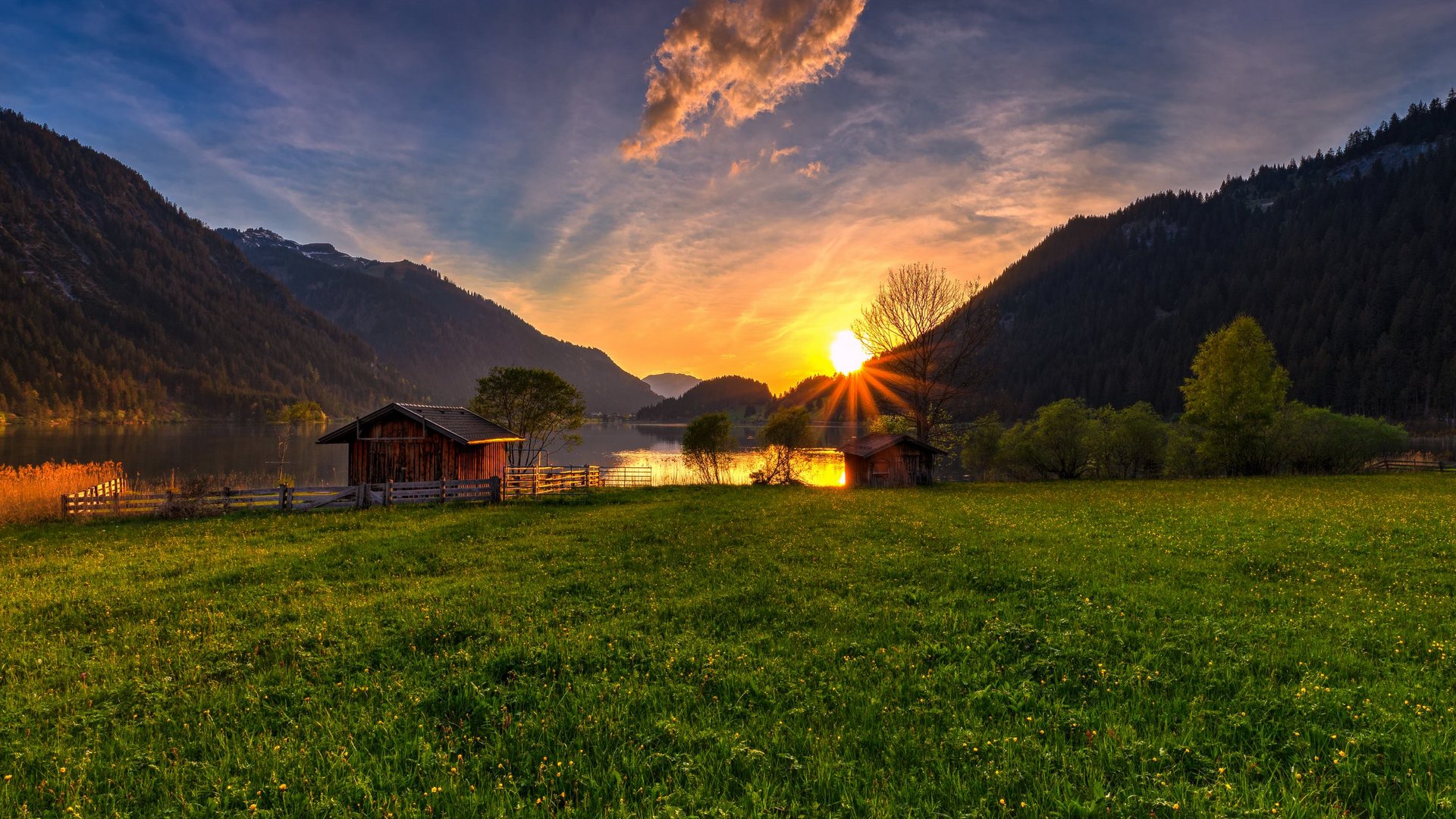 Hotel Sonnenhof Sunset over a lake with cabins and green meadow in a valley