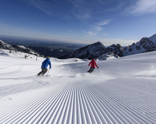 Hotel Sonnenhof Zwei Skifahrer auf frisch gespurter Piste in den Bergen bei klarem Himmel