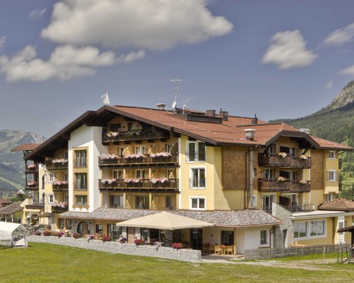 Hotel Sonnenhof Hotelgebäude in alpiner Landschaft mit Balkonblumen und Bergen im Hintergrund