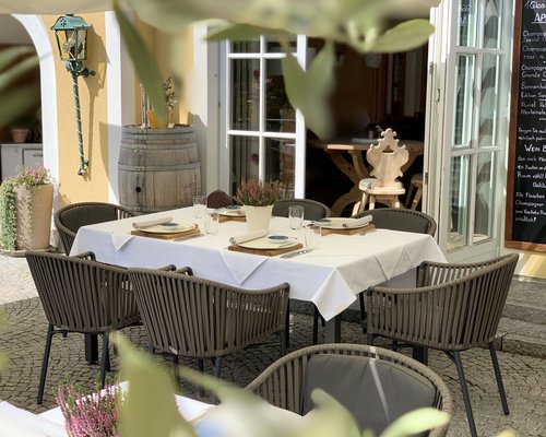 Hotel Sonnenhof Eingerichteter Tisch mit sechs Stühlen im Außenbereich eines Restaurants