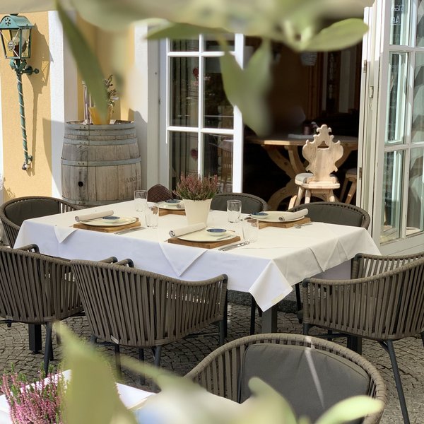 Hotel Sonnenhof Eingerichteter Tisch mit sechs Stühlen im Außenbereich eines Restaurants