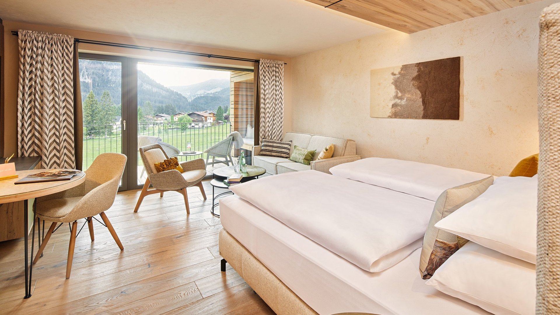 Hotel Sonnenhof Bright hotel room with double bed, seating area, and mountain view from balcony
