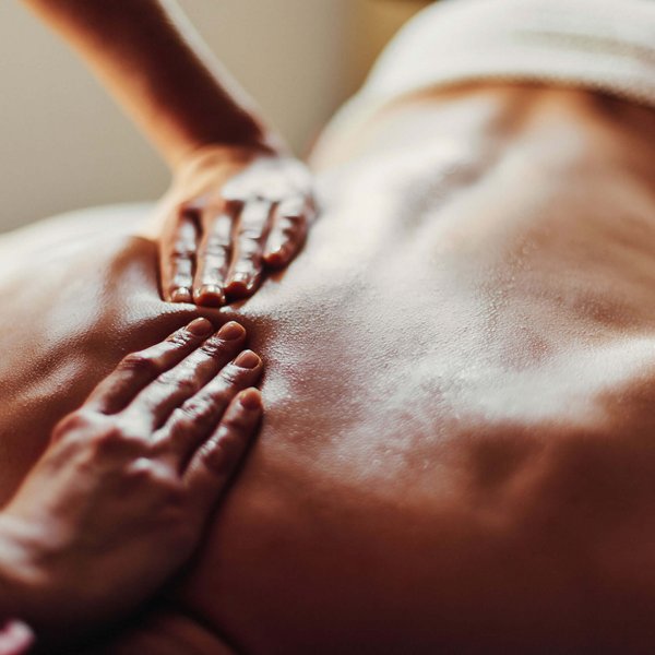 Hotel Sonnenhof Person erhält Ölmassage auf dem Rücken in entspannter Umgebung