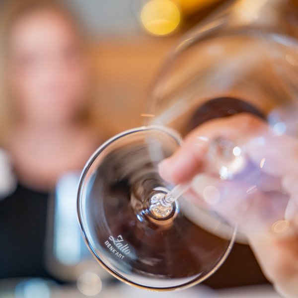 Hotel Sonnenhof Nahaufnahme eines leeren Weinglases mit verschwommener Person im Hintergrund