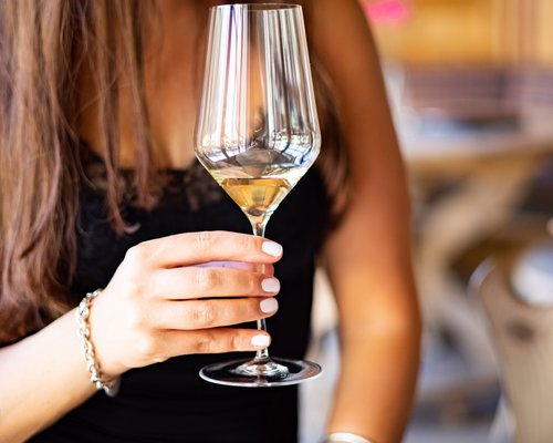 Hotel Sonnenhof Frau hält Weinglas mit weißem Wein in einem Restaurant