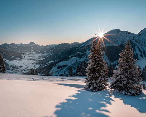 Hotel Sonnenhof Sonnenaufgang über schneebedeckten Tannen und Bergen im Winter